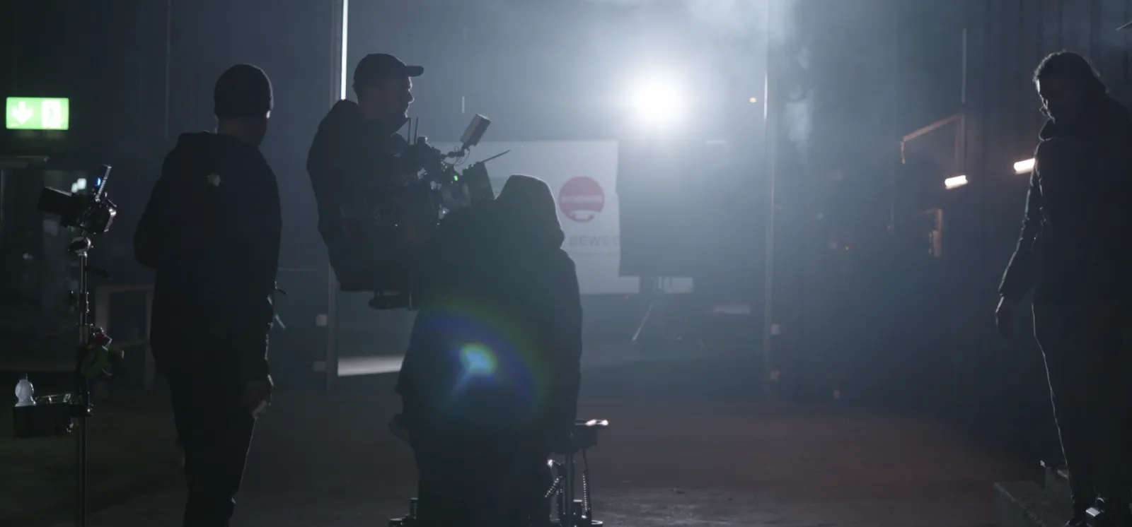 Das Set im Gegenlicht: Kamerateam und Scheinwerfer im Nebel