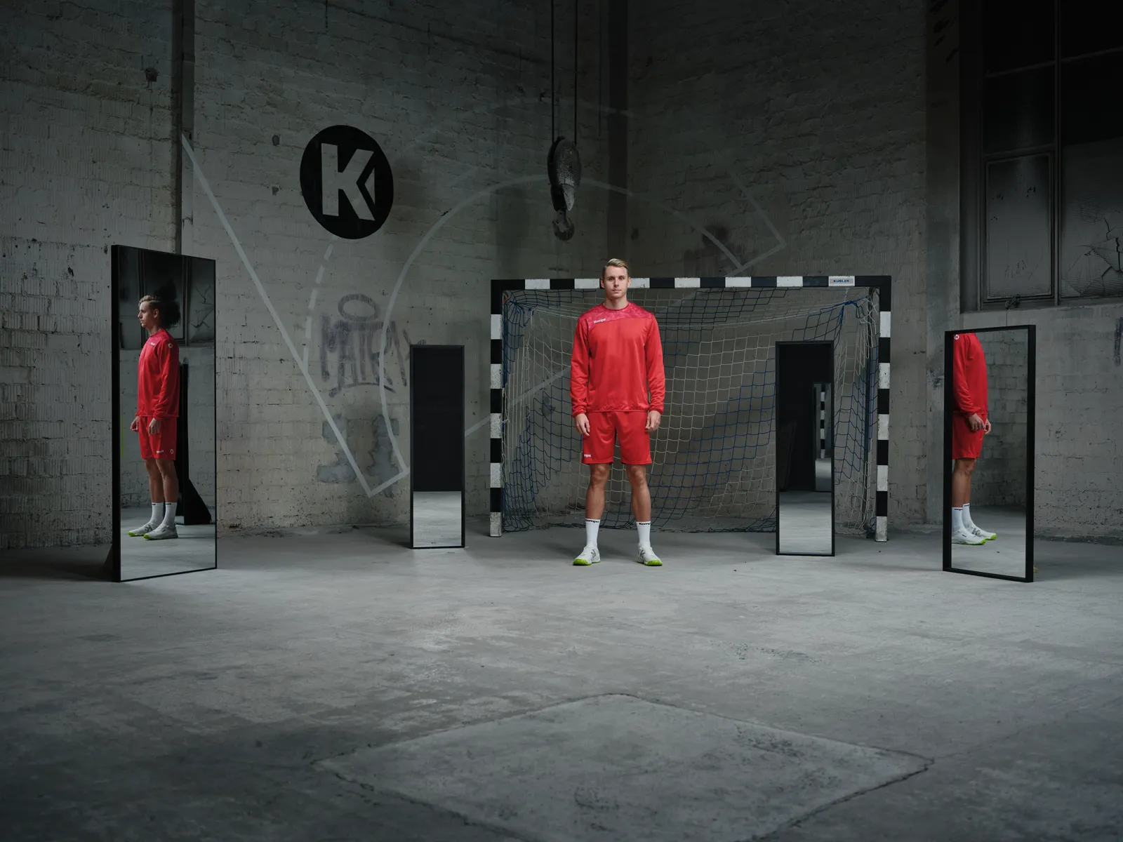 Spieler im roten Trainings-Top zwischen Spiegeln in der Halle