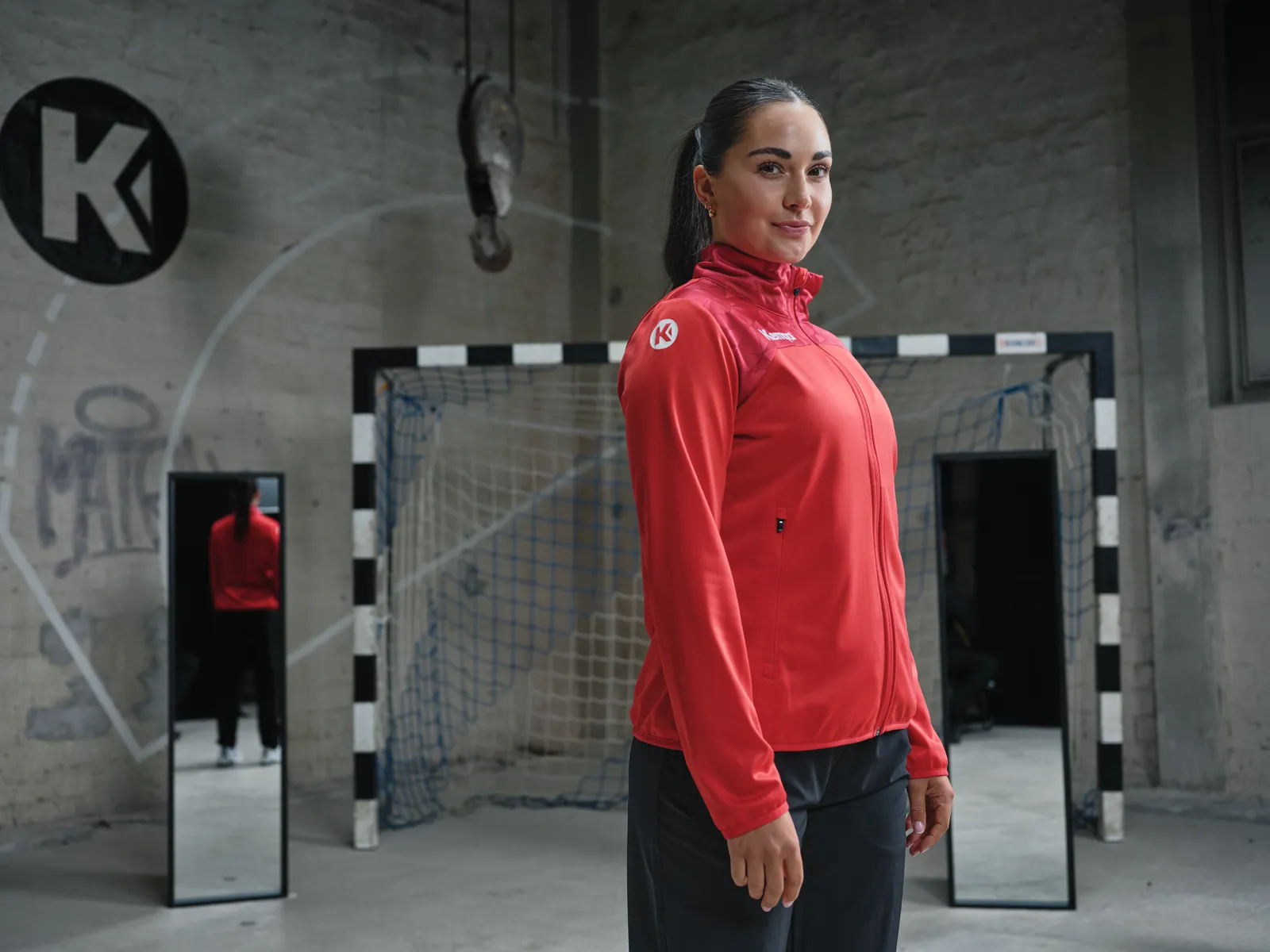 Spielerin in roter Trainingsjacke, Porträt in der Halle