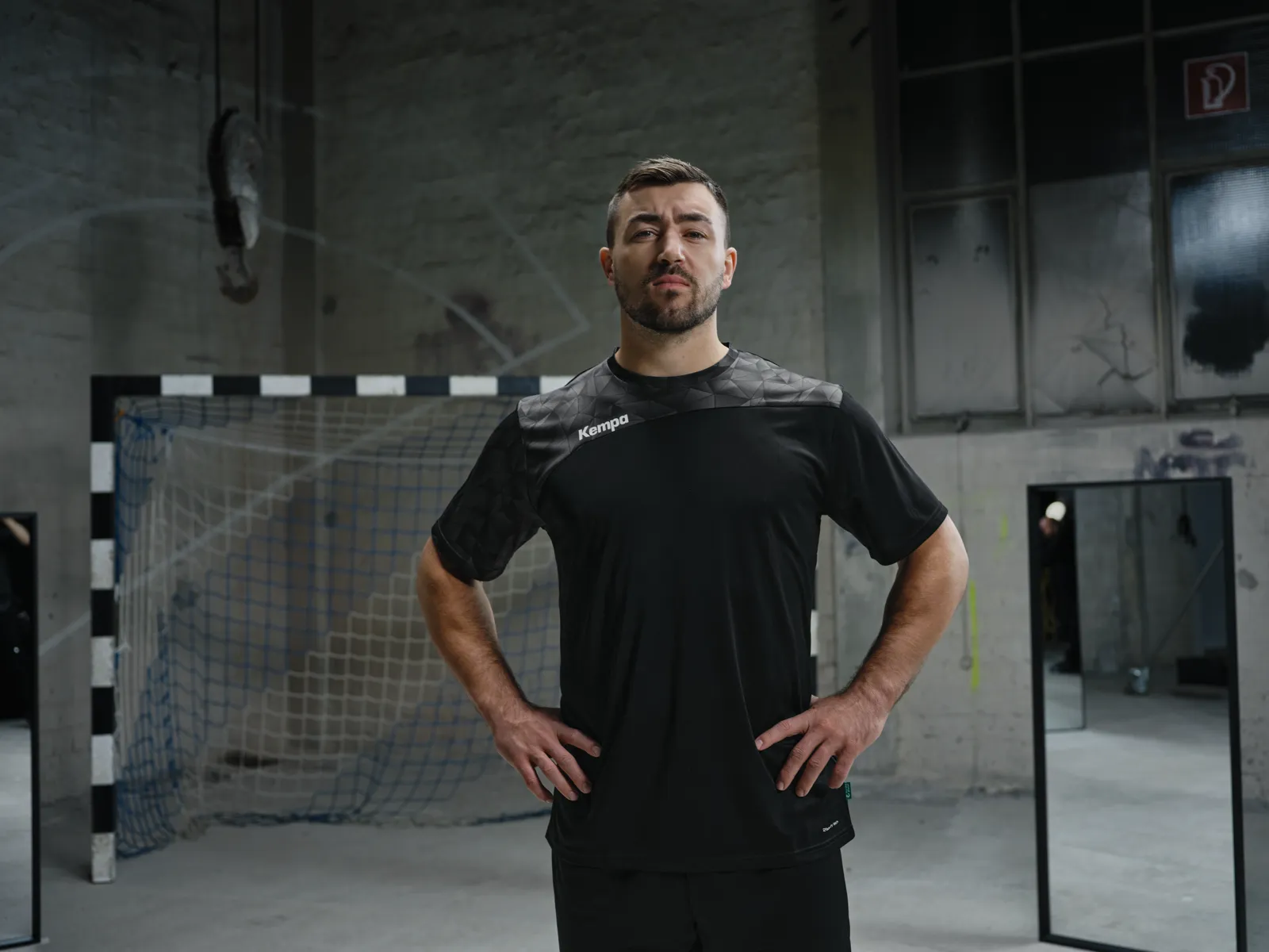 Spieler im schwarzen Trikot mit Händen an den Hüften