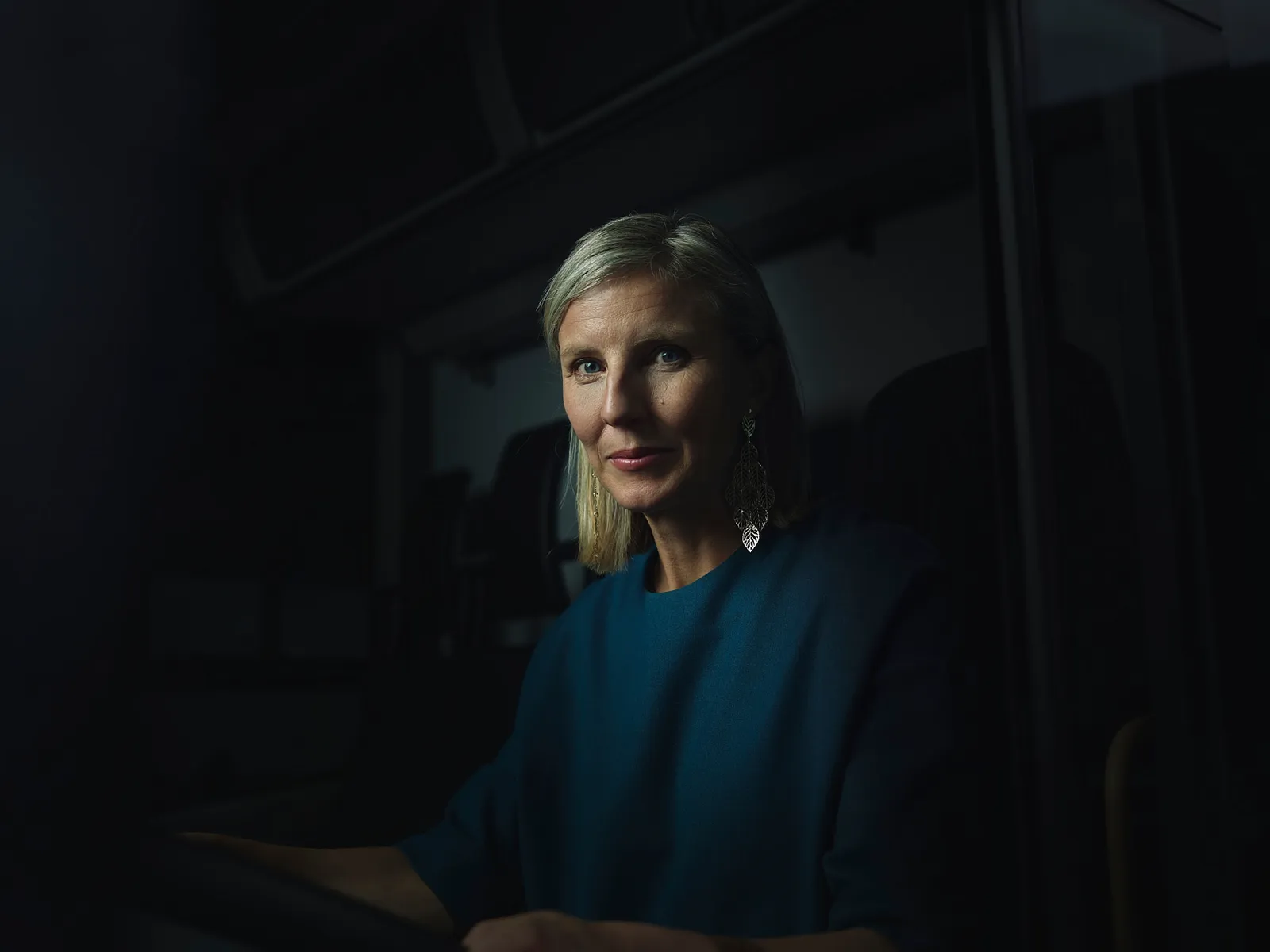 Karin Rådström frontal im dunklen Lkw-Fahrerhaus