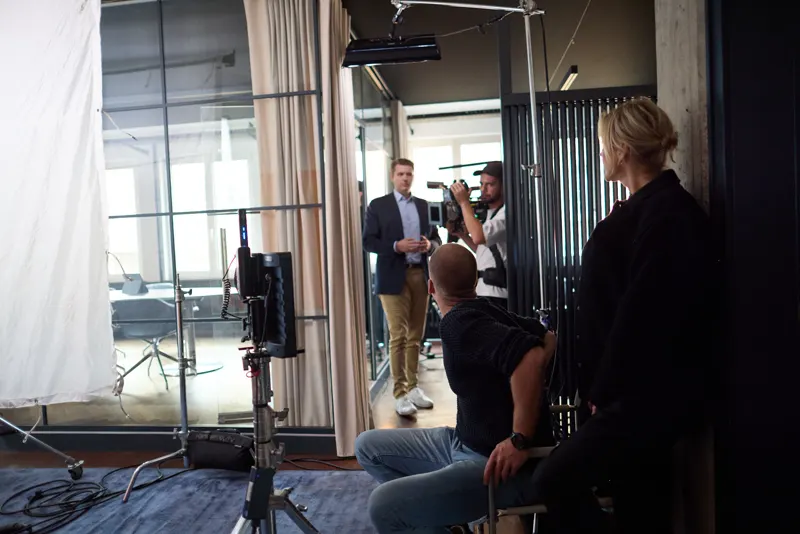 Drehsituation im Loft, das Kamerateam filmt einen Mann im Sakko
