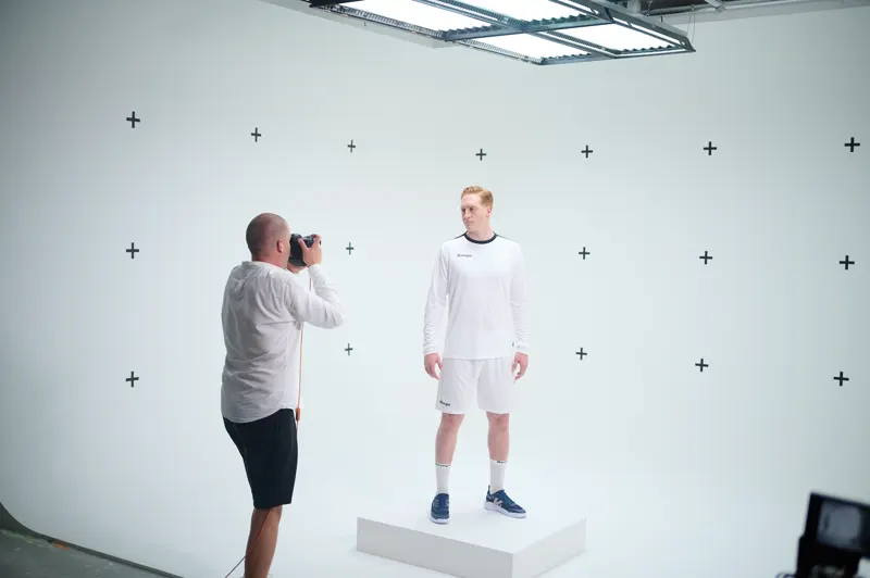 Fotograf fotografiert ein Model vor weißer Wand mit Trackingmarkern