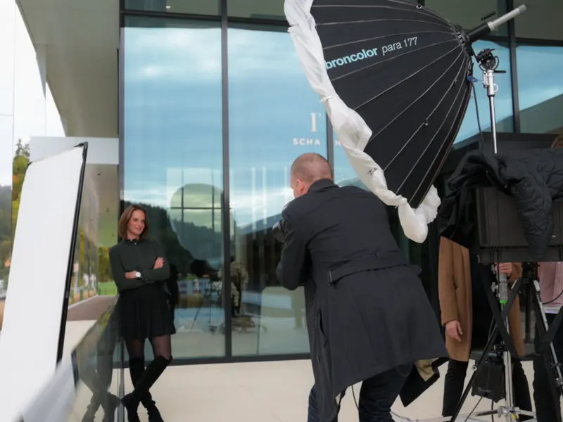 Fotograf fotografiert eine Frau unter einem großen Parabolschirm am Eingang