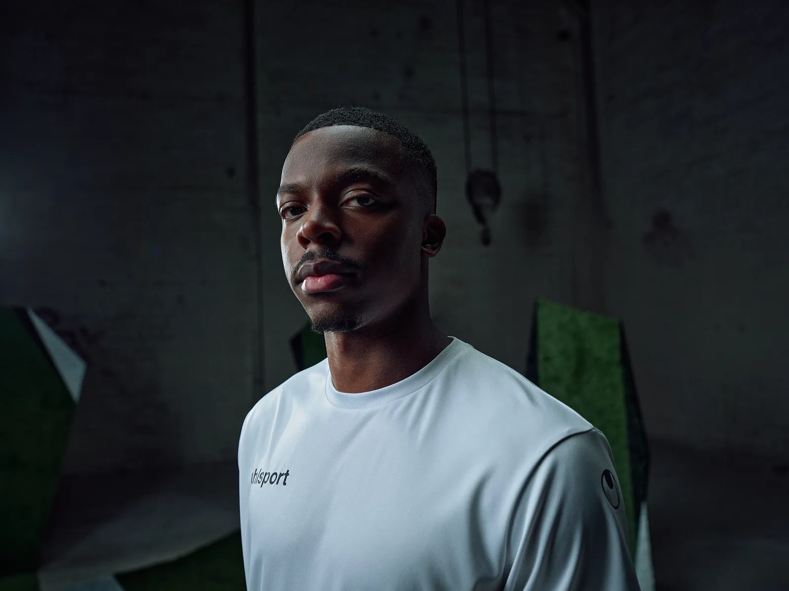 Spieler im weißen Shirt, Porträt in der dunklen Halle